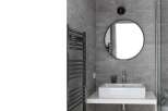 Modern bathroom design featuring a sleek, rectangular sink and a stylish round mirror.