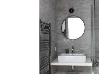 Modern bathroom design featuring a sleek, rectangular sink and a stylish round mirror.