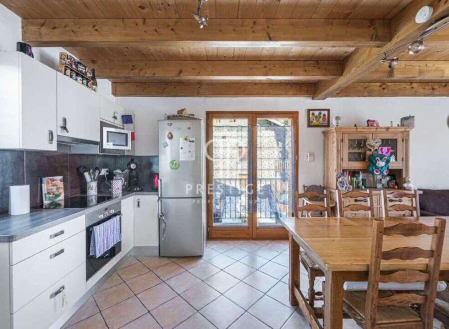 Discover a charming kitchen with a rustic touch, featuring wooden beams and a cozy dining area.