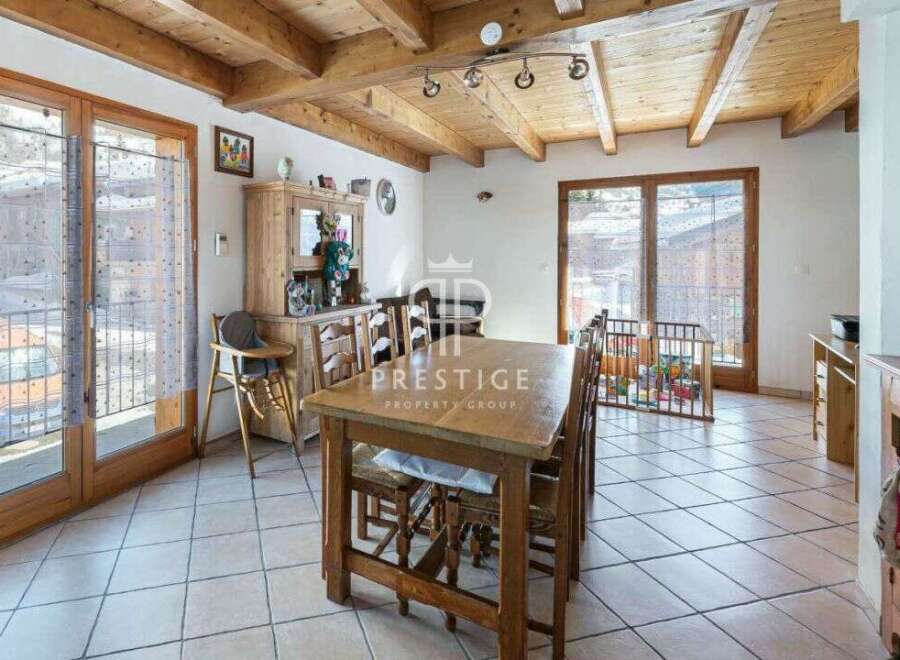 Discover the charm of this property, featuring a cozy dining area with a rustic wooden table and chairs.