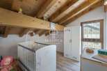Discover a charming nursery with a cozy, wooden-beamed ceiling.