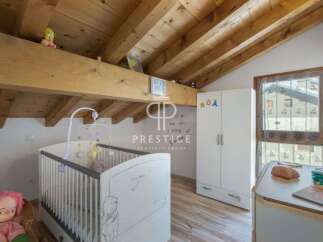 Discover a charming nursery with a cozy, wooden-beamed ceiling.