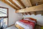 Discover a cozy bedroom with a rustic wooden ceiling and beams, creating a warm and inviting atmosphere.