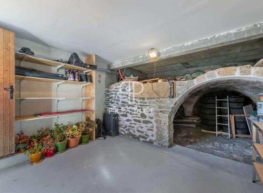 Discover the charm of this unique property, featuring a rustic stone archway and a spacious storage area.
