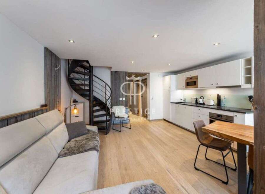 Discover modern living in this stylish property, featuring a sleek spiral staircase and a contemporary kitchen.