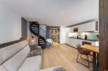 Discover modern living in this stylish property, featuring a sleek spiral staircase and a contemporary kitchen.