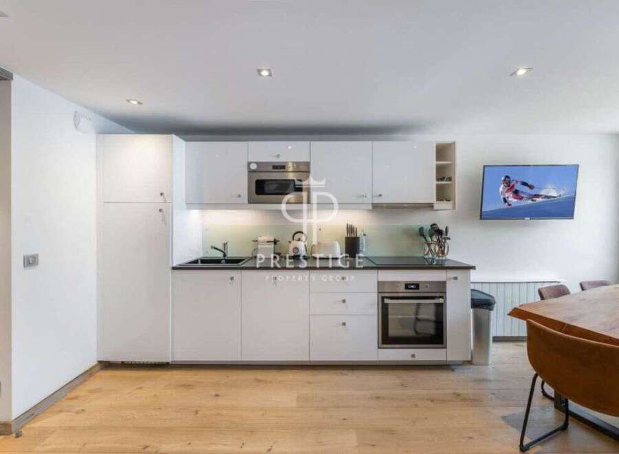 Modern kitchen with sleek white cabinetry and stainless steel appliances.