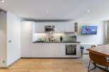 Modern kitchen with sleek white cabinetry and stainless steel appliances.