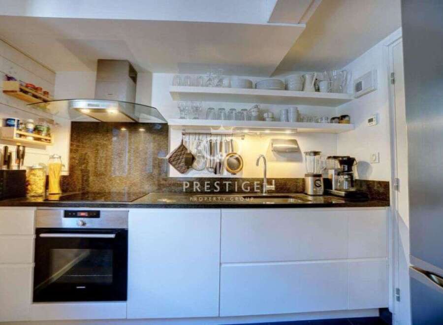 Discover a modern kitchen with sleek white cabinetry and a stylish black countertop.