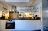 Discover a modern kitchen with sleek white cabinetry and a stylish black countertop.