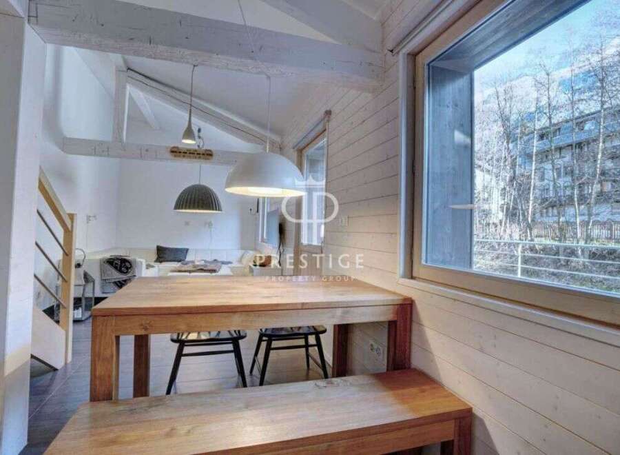 Discover a charming property with a cozy dining area, featuring a wooden table and bench.