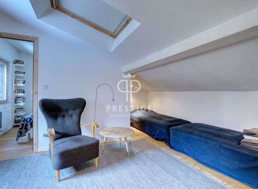 Discover this charming property featuring a cozy seating area with a stylish armchair and a small round table.
