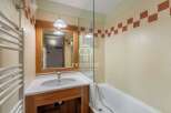 Discover a stylish bathroom featuring a sleek vanity and a modern shower enclosure.