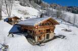 Discover a stunning chalet nestled in a snowy mountain landscape.
