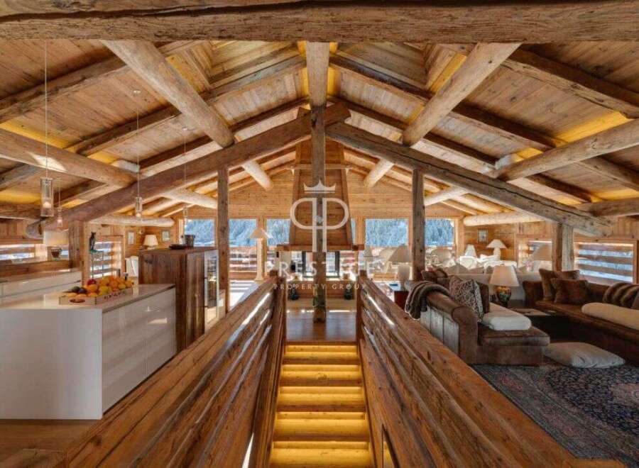 Experience luxury living in this stunning chalet, featuring a warm and inviting interior with exposed wooden beams and a cozy atmosphere.