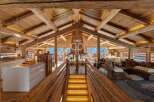 Experience luxury living in this stunning chalet, featuring a warm and inviting interior with exposed wooden beams and a cozy atmosphere.
