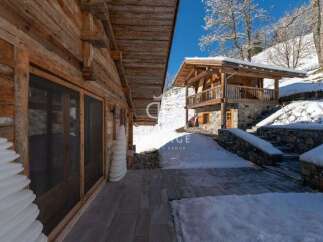 Discover the charm of this stunning wooden chalet nestled in a snowy landscape.