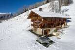 Discover a stunning chalet nestled in a snowy mountain landscape.
