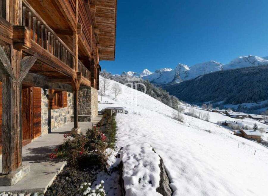 Experience the charm of a traditional wooden chalet nestled in a snowy mountain landscape.