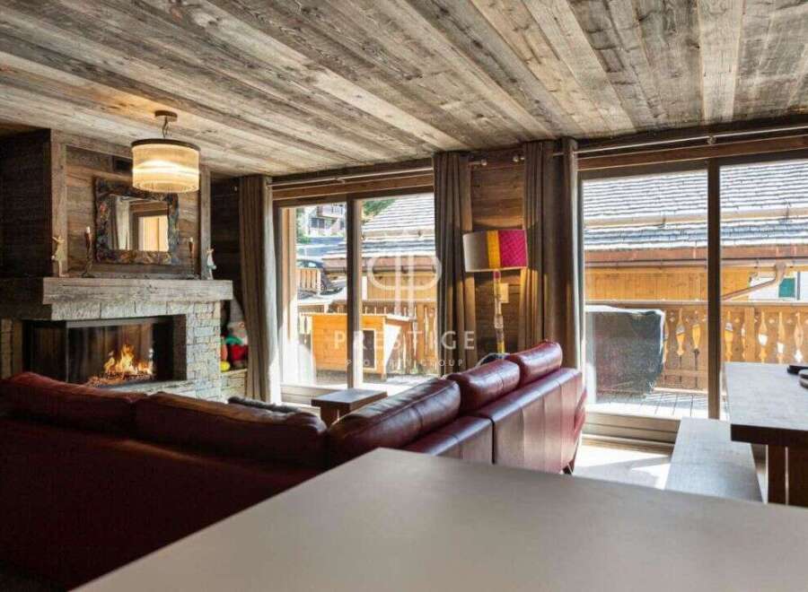 Experience the warmth of this cozy living space, featuring a stunning fireplace and rustic wooden accents.