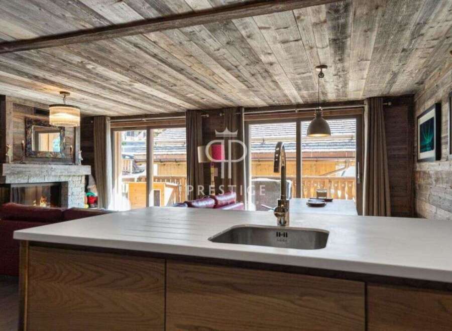 Experience luxury living in this stunning property, featuring a cozy fireplace and a modern kitchen with a sleek countertop.