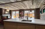 Experience luxury living in this stunning property, featuring a cozy fireplace and a modern kitchen with a sleek countertop.