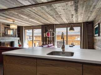Experience luxury living in this stunning property, featuring a cozy fireplace and a modern kitchen with a sleek countertop.
