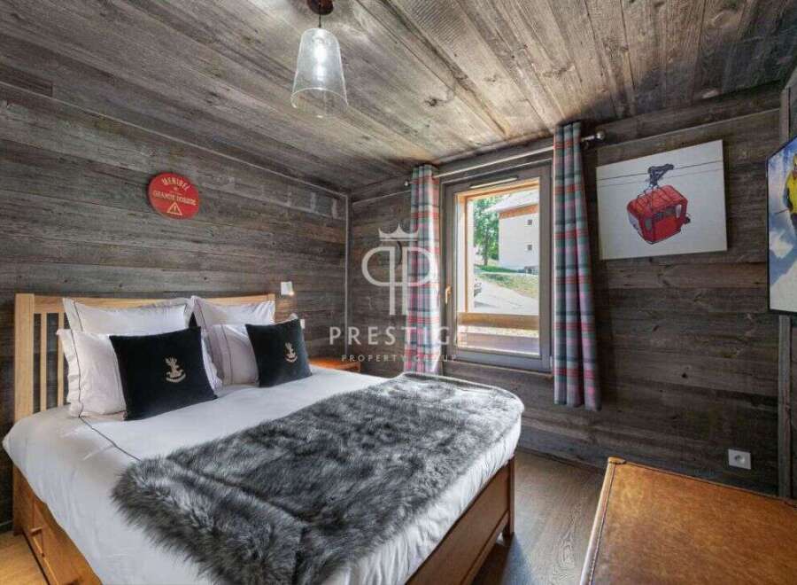 Experience rustic charm in this cozy bedroom, featuring wood-paneled walls and ceiling.