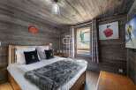 Experience rustic charm in this cozy bedroom, featuring wood-paneled walls and ceiling.
