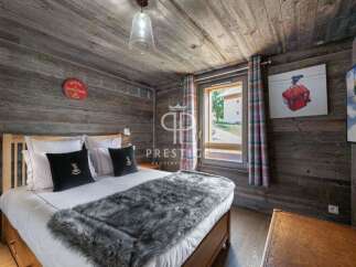 Experience rustic charm in this cozy bedroom, featuring wood-paneled walls and ceiling.