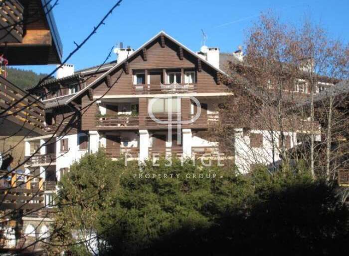 Discover a stunning property with a charming wooden facade and multiple balconies, perfect for enjoying scenic views.