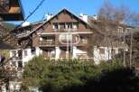 Discover a stunning property with a charming wooden facade and multiple balconies, perfect for enjoying scenic views.
