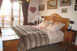 This charming bedroom boasts a rustic wooden headboard and a cozy, inviting atmosphere.