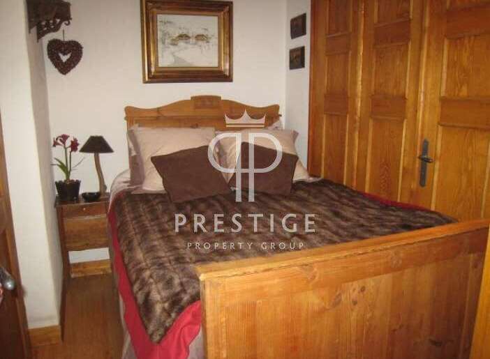 Cozy bedroom with a rustic wooden bed frame and headboard.