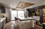 This stunning kitchen boasts a modern design with dark cabinetry, marble countertops, and a statement island.