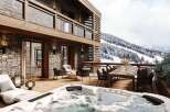 Luxury chalet with stunning mountain views, featuring a spacious outdoor deck complete with a hot tub, dining area, and comfortable seating around a fire pit.