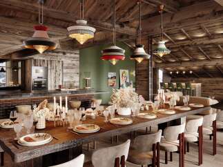 This stunning chalet boasts a spacious dining area with a long wooden table perfect for gatherings, complemented by unique pendant lights and a cozy fireplace.