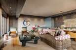 This stunning living space boasts a chic and modern design, featuring a comfortable striped sofa, stylish armchairs, and a sleek coffee table.