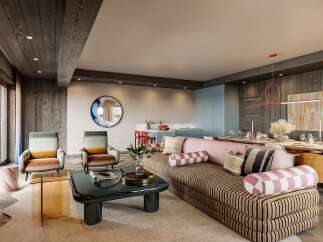 This stunning living space boasts a chic and modern design, featuring a comfortable striped sofa, stylish armchairs, and a sleek coffee table.
