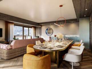 This luxurious apartment boasts a spacious open-plan living area with stunning mountain views, a chic dining setting perfect for entertaining, and a modern kitchen.