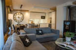 This stunning apartment boasts an open-plan living area with a cozy sofa and a modern kitchen, perfect for entertaining guests.