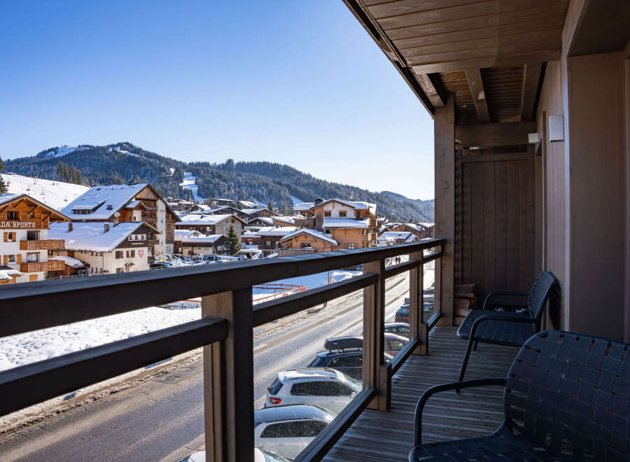 This stunning property boasts a spacious balcony with breathtaking views of the snow-capped mountains and charming village below.