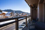 This stunning property boasts a spacious balcony with breathtaking views of the snow-capped mountains and charming village below.