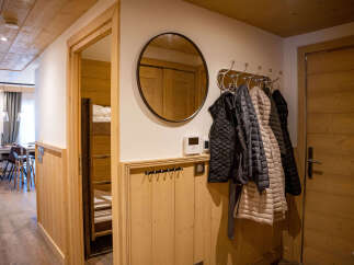 This cozy apartment boasts a charming wooden interior with a bunk bed tucked away in a hallway alcove.