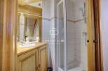 Discover a charming bathroom with a rustic wooden vanity and a sleek glass shower enclosure.
