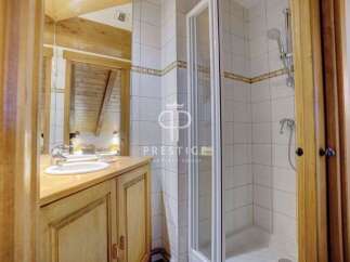 Discover a charming bathroom with a rustic wooden vanity and a sleek glass shower enclosure.