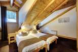 Discover the charm of this cozy bedroom, featuring a unique sloped ceiling with exposed wooden beams.