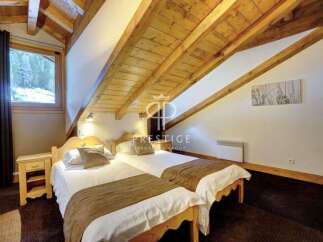 Discover the charm of this cozy bedroom, featuring a unique sloped ceiling with exposed wooden beams.