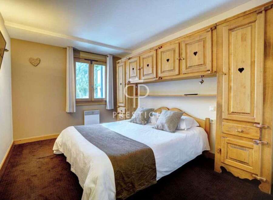 Cozy bedroom with wooden furniture and a comfortable bed.