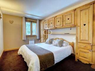 Cozy bedroom with wooden furniture and a comfortable bed.